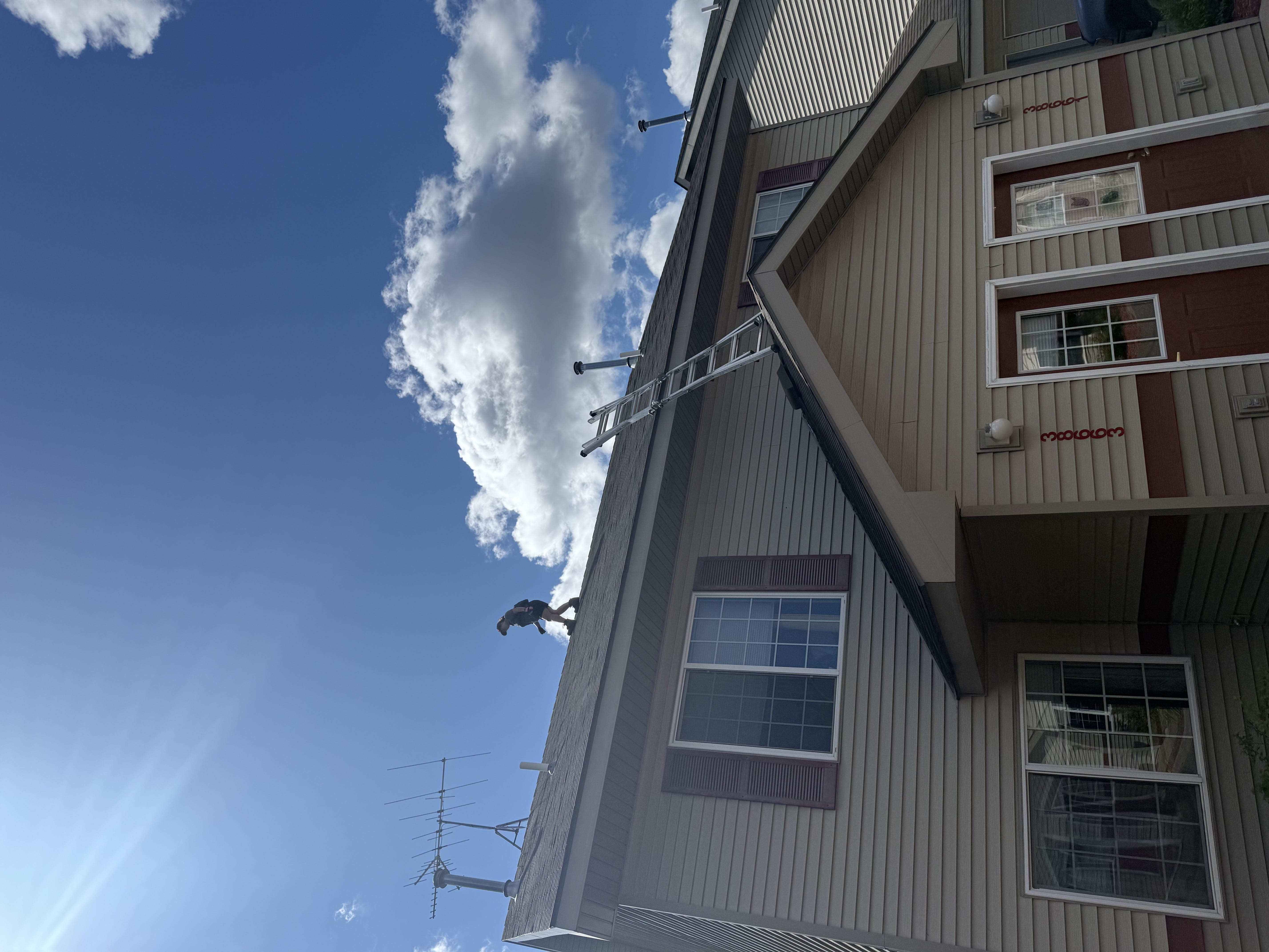 Drone roof inspection in progress on a sunny Faribault MN residential and commercial property